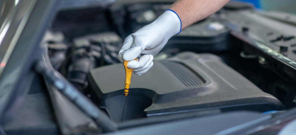 Man changing oil as part of routine car maintenance