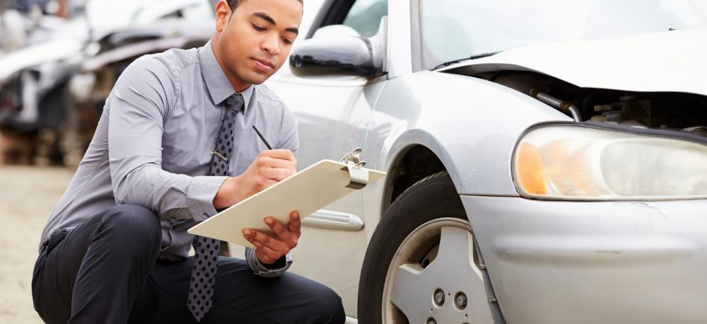 Man inspecting a vehicle after a collision